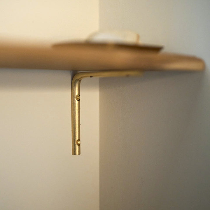 半円形の真鍮棒がゆるやかな弧を描く。やわらかい印象の棚受け金具です。