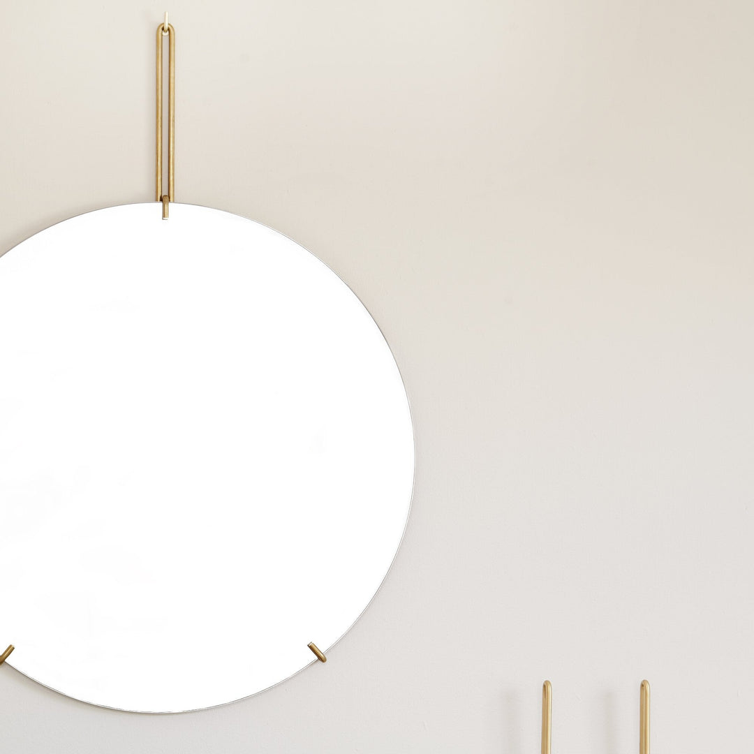 一枚の鏡と、真鍮の金具だけで構成されたミニマルなフレームレスミラー