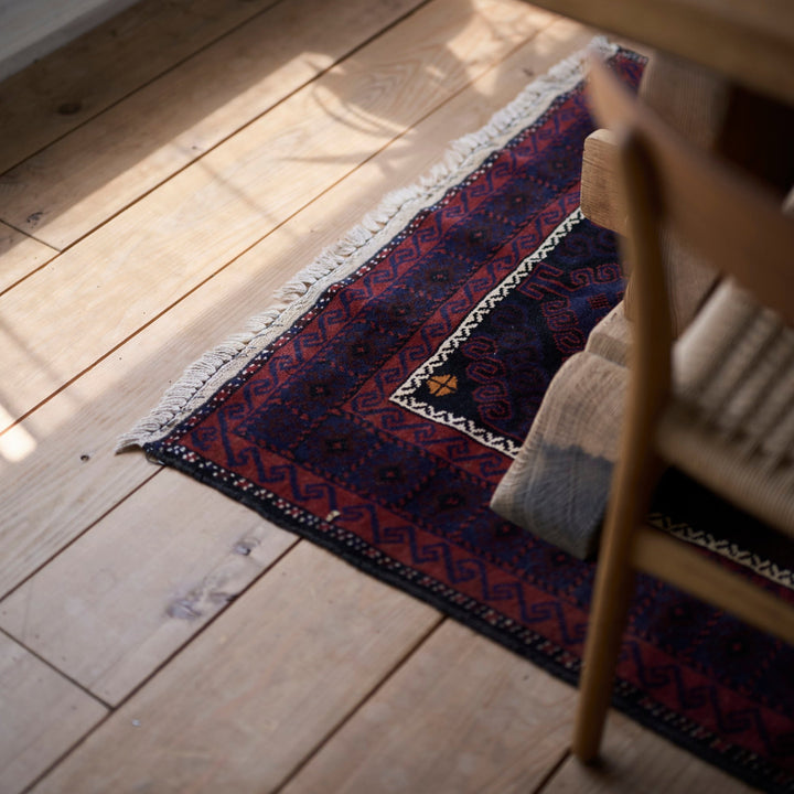 深い藍を背景に、赤やワインレッドが交差する力強い幾何学模様。